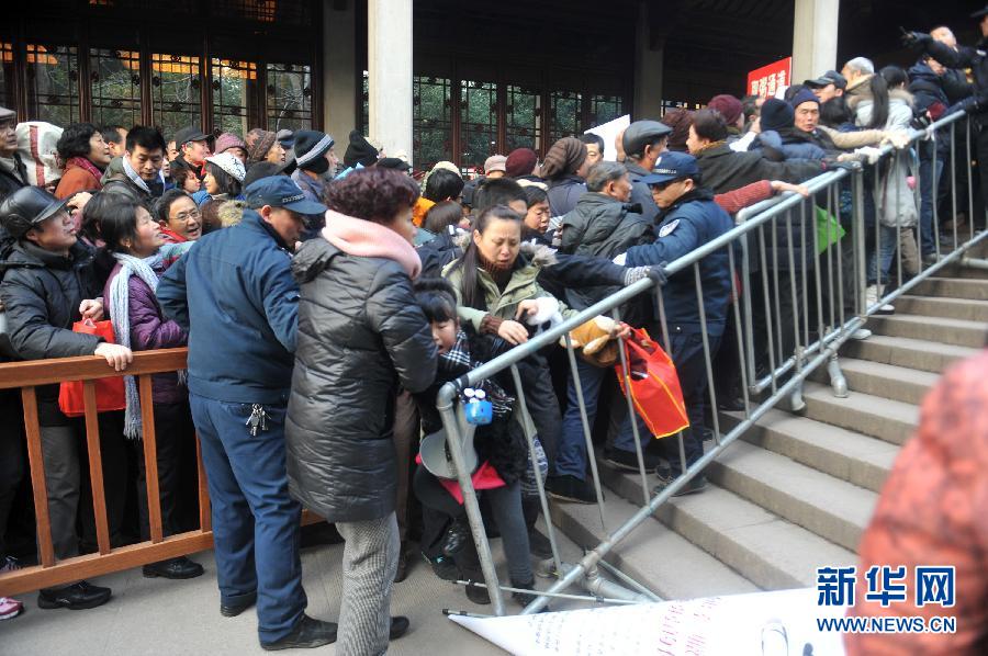 Free Laba porridge is given out in Lingyin Temple in Hangzhou on Jan. 19, 2013. On the day people could enter the temple without entrance ticket and get free porridge. Numerous people, however, failed to queue up and gave rise to the mess in the crowd. The little girl and her mother are squeezed out. (Photo/Xinhua) 