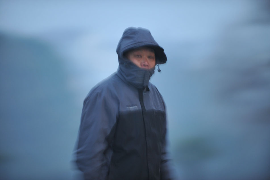 A man is seen in the fog enveloped street in Hefei, Anhui province, Jan. 13, 2012. (Xinhua/Yang Xiaoyuan)