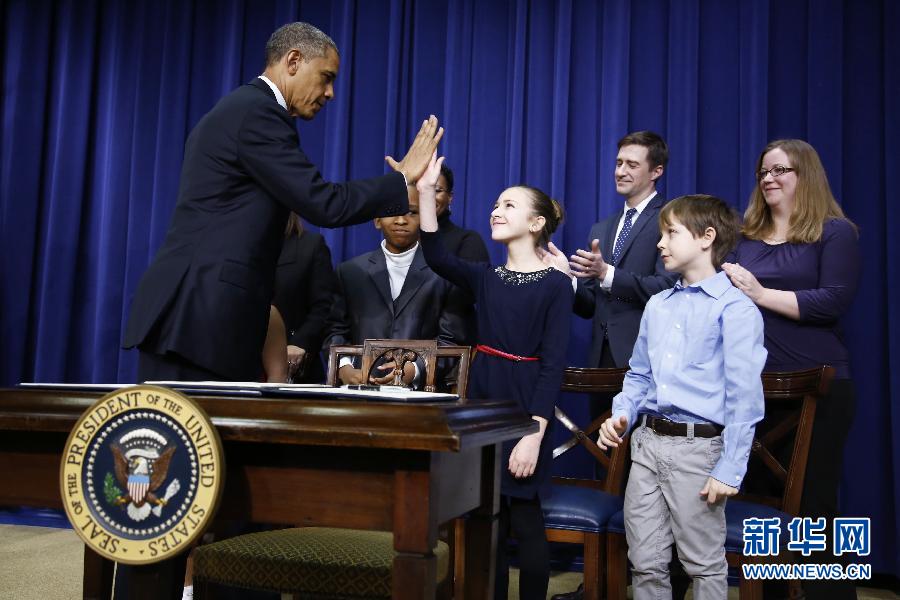 U.S. president Barack Obama gives high five to a student who wrote him a letter after the tragic Sandy Hook school shooting in White House in Washington D.C., U.S., Jan. 16, 2013.On the same day, President Obama announced the comprehensive gun control policies in White House, covering laws, education, health and science research. (Xinhua/Reuters)