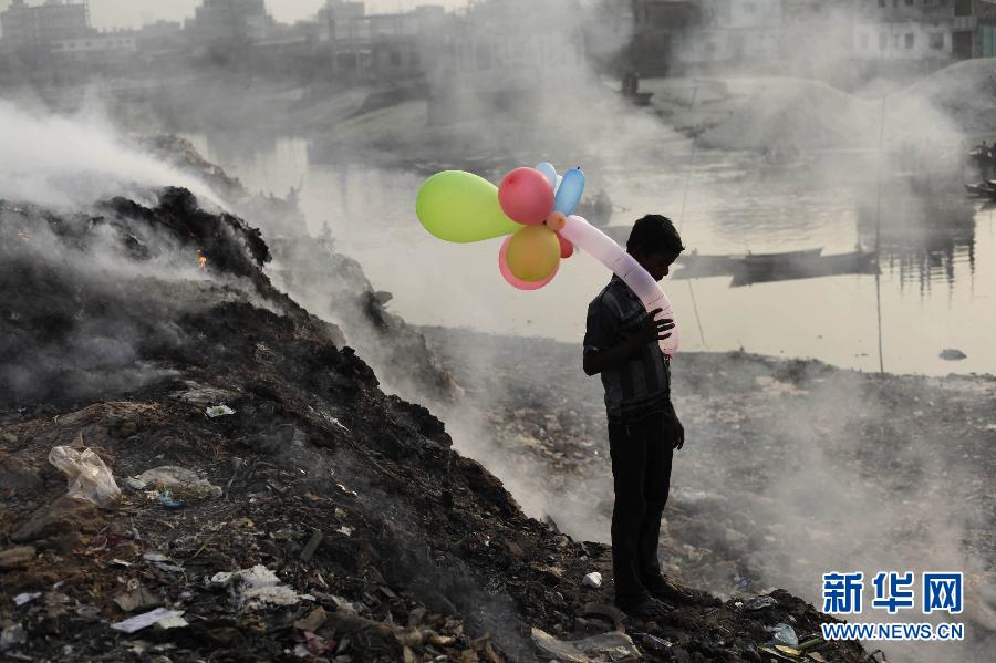 A boy holds a balloon in the middle of a garbage dump in Bengel Dhara, Jan. 19, 2013.(Xinhua/Reuters)