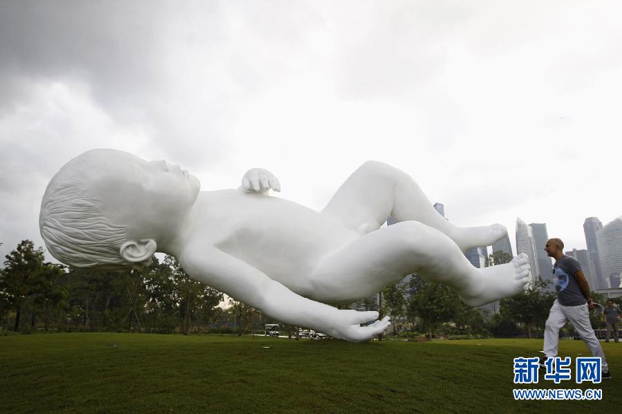 Mark Quinn, a British sculptor, walks by his recently unveiled sculpture “planet” in Singapore, Jan. 18, 2013.(Xinhua/Reuters)  