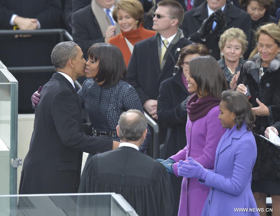 U.S. President Barack Obama (L) kisses his wife after he was sworn in for his second term during the presidential inauguration ceremony on the West Front of the U.S. Capitol in Washington D.C., the United States, on Jan. 21, 2013. (Xinhua/Zhang Jun) 