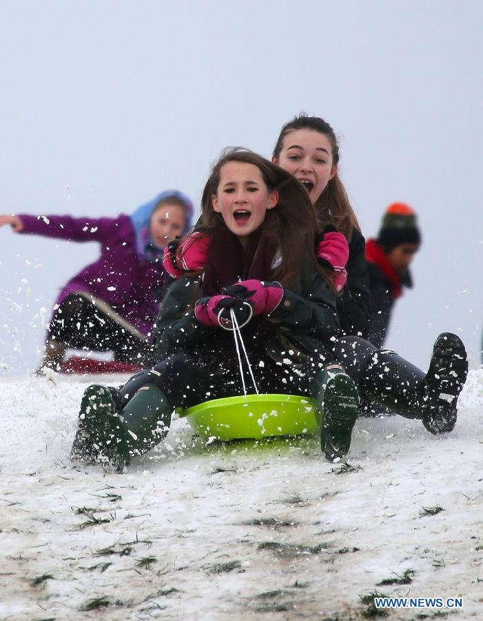 People sledge in the snow in Primrose Hill Park in London, Britain, Jan. 21, 2013. (Xinhua/Yin Gang)
