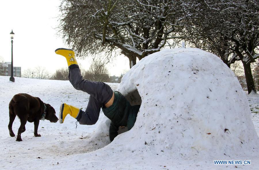 A child plays in the snow house in London, Britain, Jan. 21, 2013. (Xinhua/Yin Gang)