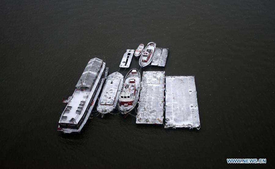 The boats and pontoon bridges on the Thames River near East India Dock are seen after a snowfall in London, Britain, Jan. 18, 2013. (Xinhua/Wang Lili) 