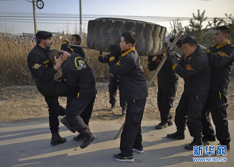 Sun Weihua is hit by the drill master because of his laziness during the 6-mile-tyre carrying training. The drill, aiming at cultivating the team work spirit, is to challenge the best and limit of individuals. As a professional security guard, one has to achieve what he seems impossible to do. (Photo/Xinhua)