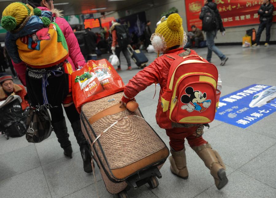 A girl from southwest China's Guizhou Province follows her mother into Hangzhou train station to wait for their train home in Hangzhou, capital of east China's Zhejiang Province, Jan. 22, 2013. Her parents now work in Fuyang of Zhejiang. Many migrant workers and their children have started to return home in order to avoid the Spring Festival travel peak that begins on Jan. 26 and will last for about 40 days. The Spring Festival, the most important occasion for a family reunion for the Chinese people, falls on the first day of the first month of the traditional Chinese lunar calendar, or Feb. 10 this year. (Xinhua/Han Chuanhao)