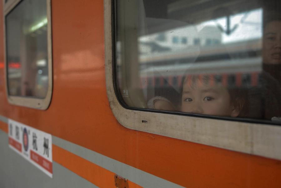 A child looks out of a window of a train from Hangzhou to Guiyang, capital of southwest China's Guizhou Province, in Hangzhou, capital of east China's Zhejiang Province, Jan. 22, 2013. Many migrant workers and their children have started to return home in order to avoid the Spring Festival travel peak that begins on Jan. 26 and will last for about 40 days. The Spring Festival, the most important occasion for a family reunion for the Chinese people, falls on the first day of the first month of the traditional Chinese lunar calendar, or Feb. 10 this year. (Xinhua/Han Chuanhao)