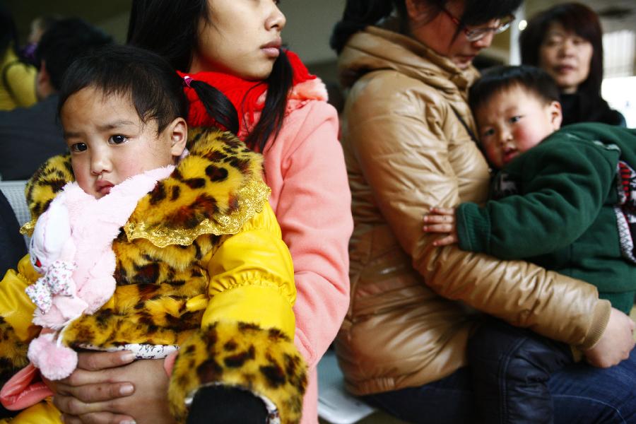 Tian Xin, a three-year-old girl from central China's Hunan Province, waits for her train home in her mother's arms at Hangzhou train station in Hangzhou, capital of east China's Zhejiang Province, Jan. 22, 2013. Many migrant workers and their children have started to return home in order to avoid the Spring Festival travel peak that begins on Jan. 26 and will last for about 40 days. The Spring Festival, the most important occasion for a family reunion for the Chinese people, falls on the first day of the first month of the traditional Chinese lunar calendar, or Feb. 10 this year. (Xinhua/Cui Xinyu)