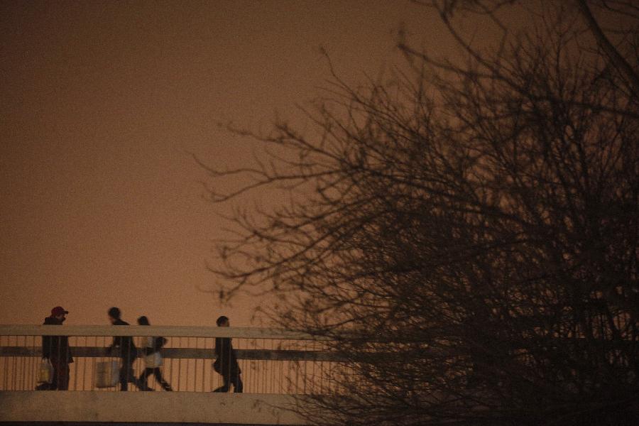 Pedestrians are seen in the fog in Beijing, capital of China, Jan. 22, 2013. Beijing meteorological observatory issued a yellow alert for heavy fog on Tuesday. (Xinhua/Wang Shen)
