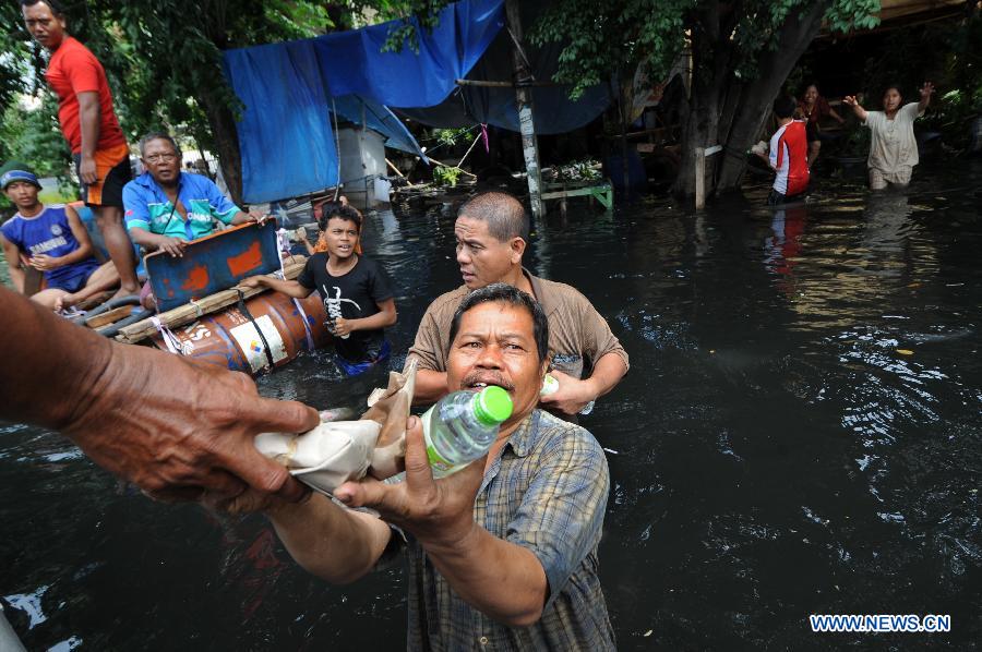 Refugees receive food and water at Pluit in North Jakarta, Indonesia, Jan. 22, 2013. According to Indonesia's National Agency for Disaster Management (BNPB), around 20 people died from the recent massive flood that hit Jakarta.(Xinhua/Veri Sanovri)  