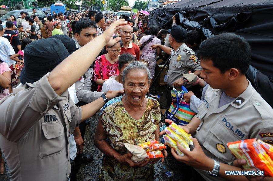 Refugees queue up for food at Penjaringan in North Jakarta, Indonesia, Jan. 22, 2013. According to Indonesia's National Agency for Disaster Management (BNPB), around 20 people died from the recent massive flood that hit Jakarta. (Xinhua/Veri Sanovri)  