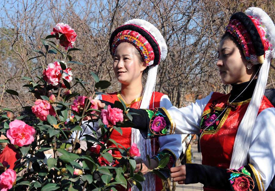 Girls watch camellia flowers during the 2013 Kunming Camellia Festival at Green Lake Park in Kunming, capital of southwest China's Yunnan Province, Jan. 22, 2013. The festival opened here Tuesday. (Xinhua/Yang Zongyou) 