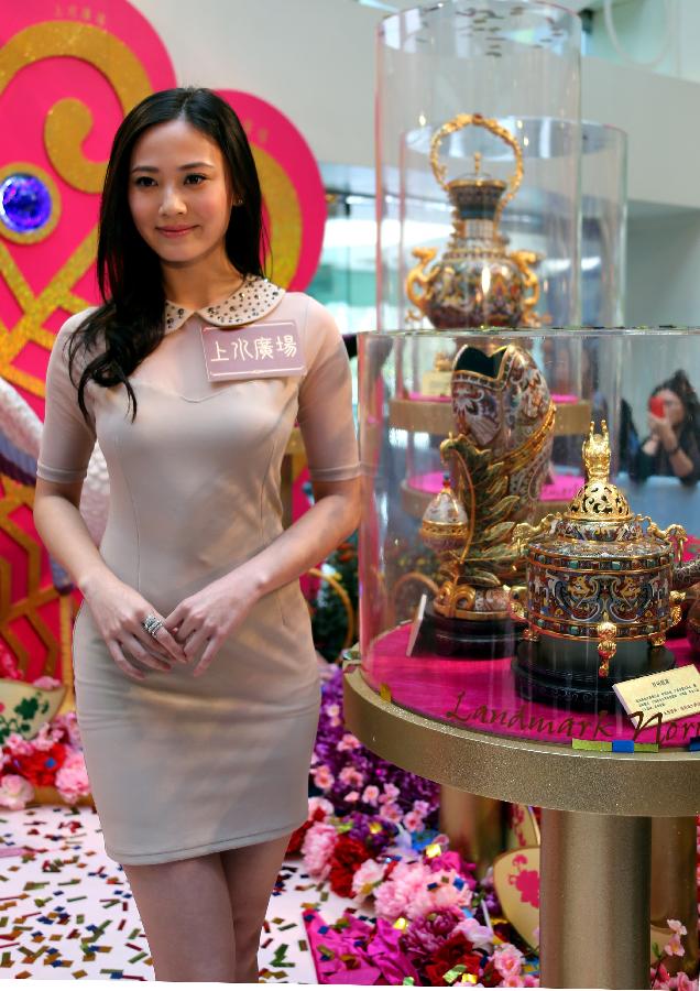Rebecca Zhu, the winner of 2011 Miss Hong Kong, poses with cloisonne works made by artist Zhang Tonglu during an exhibition in south China's Hong Kong, Jan. 22, 2013. An exhibition of Zhang Tonglu's cloisonne art works was held here on Tuesday, showing 22 pieces of cloisonne works. (Xinhua/Li Peng) 