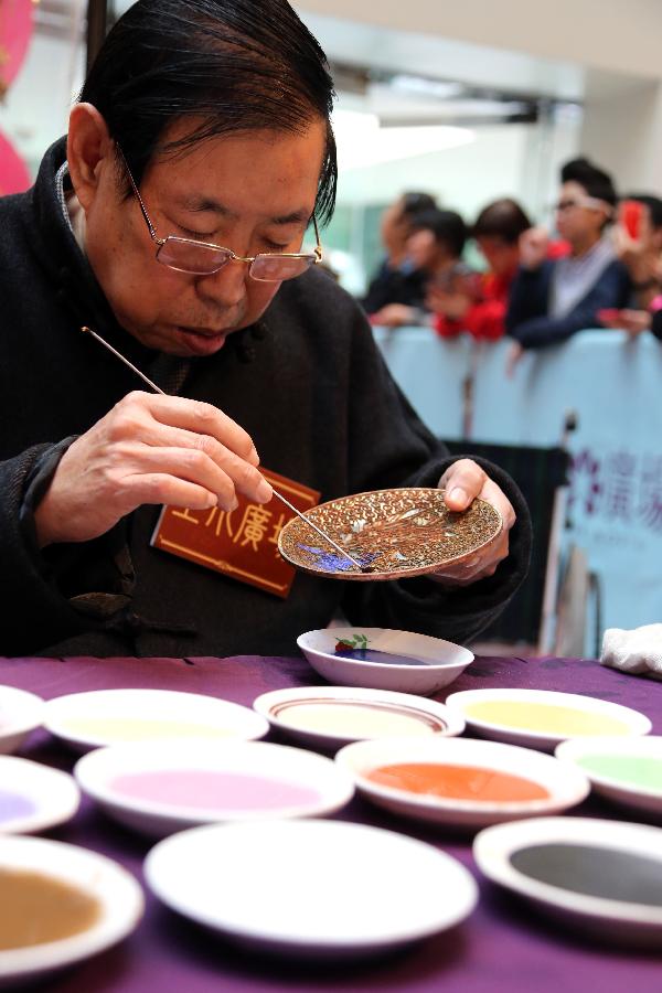 Artist Zhang Tonglu works on a piece of cloisonne work during an exhibition in south China's Hong Kong, Jan. 22, 2013. An exhibition of Zhang Tonglu's cloisonne art works was held here on Tuesday, showing 22 pieces of cloisonne works. (Xinhua/Li Peng) 