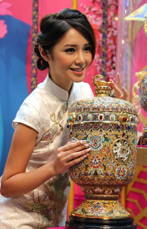 A piece of cloisonne work made by artist Zhang Tonglu is presented by Elva Ni, the winner of 2005 Miss Chinese Toronto Pageant, during an exhibition in south China's Hong Kong, Jan. 22, 2013. An exhibition of Zhang Tonglu's cloisonne art works was held here on Tuesday, showing 22 pieces of cloisonne works. (Xinhua/Li Peng) 