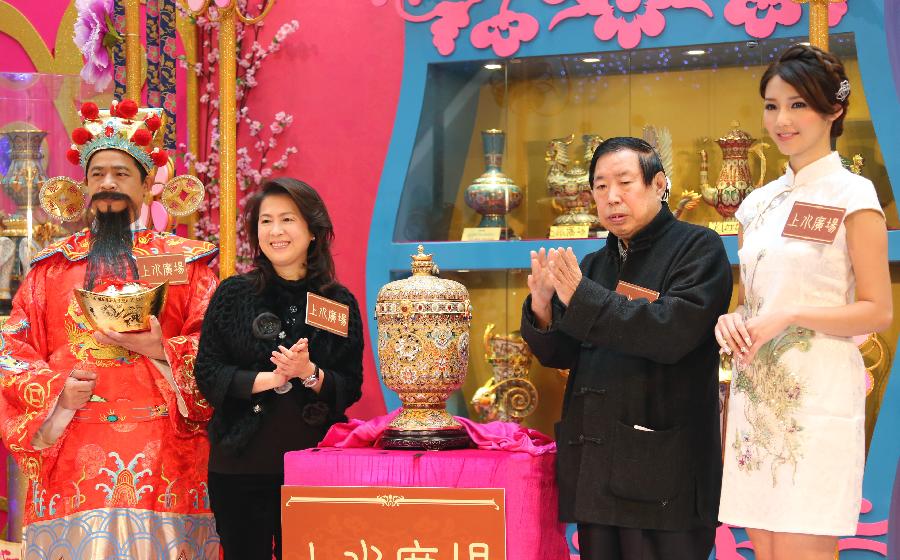 Artist Zhang Tonglu (2nd R), unveils a newly-designed piece of cloisonne work during an exhibition in south China's Hong Kong, Jan. 22, 2013. An exhibition of Zhang Tonglu's cloisonne art works was held here on Tuesday, showing 22 pieces of cloisonne works. (Xinhua/Li Peng) 