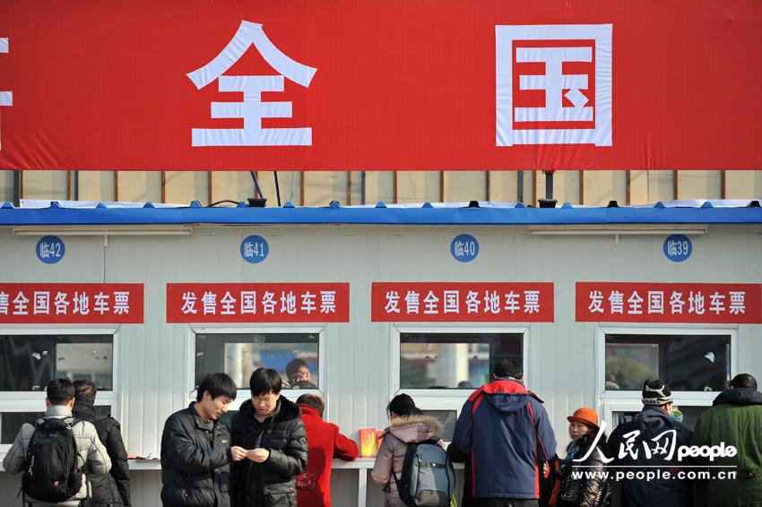 Homecoming people buy train ticket with anxiety outside a temporary ticket booth set at Beijing Railway Station, Jan. 22. The Spring Festival travel peak is going to begin on Jan. 26 and will last about 40 days. Railway passenger trips are expected to hit 225 million during the upcoming travel peak. (People’s Daily Online/Weng Qiyu)