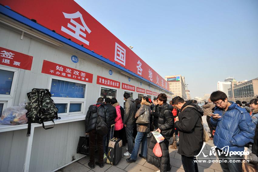 Homecoming people buy train ticket with anxiety outside a temporary ticket booth set at Beijing Railway Station, Jan. 22. The Spring Festival travel peak is going to begin on Jan. 26 and will last about 40 days. Railway passenger trips are expected to hit 225 million during the upcoming travel peak. (People’s Daily Online/Weng Qiyu)