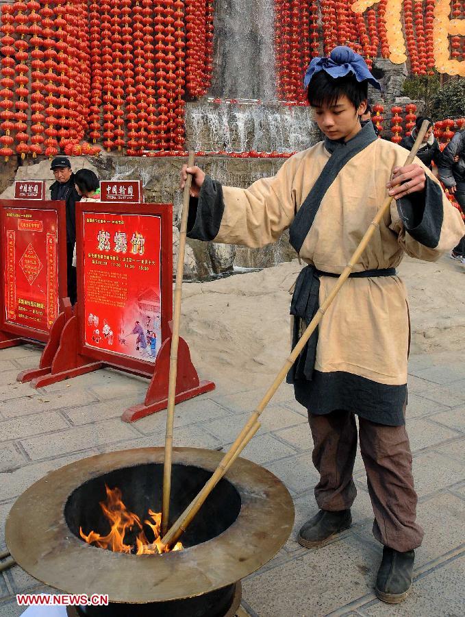 File photo taken on Feb. 8, 2011 shows an actor dressed as a citizen in the Song Dynasty (960-1279) ignites firecrackers at a temple fair in Kaifeng City, central China's Henan Province. Temple fair in central China area is an important social activity for local people. The ancient temple fairs in central China were ceremonious sacrificial rituals. As time goes by, the focus of temple fair activities has shifted from "gods" to "people". The modern temple fair in central China is a platform of displaying folk culture as well as a channel for commodity circulation. According to statistics from the provincial cultural sector, there are about 35,000 temple fairs each year in Henan. (Xinhua/Wang Song)