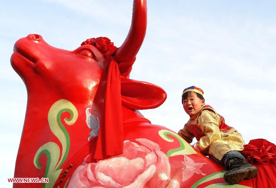 File photo taken on Jan. 21, 2009 shows a little boy rides on a "lucky bull" at a temple fair in Zhengzhou, capital of central China's Henan Province. Temple fair in central China area is an important social activity for local people. The ancient temple fairs in central China were ceremonious sacrificial rituals. As time goes by, the focus of temple fair activities has shifted from "gods" to "people". The modern temple fair in central China is a platform of displaying folk culture as well as a channel for commodity circulation. According to statistics from the provincial cultural sector, there are about 35,000 temple fairs each year in Henan. (Xinhua/Wang Song)