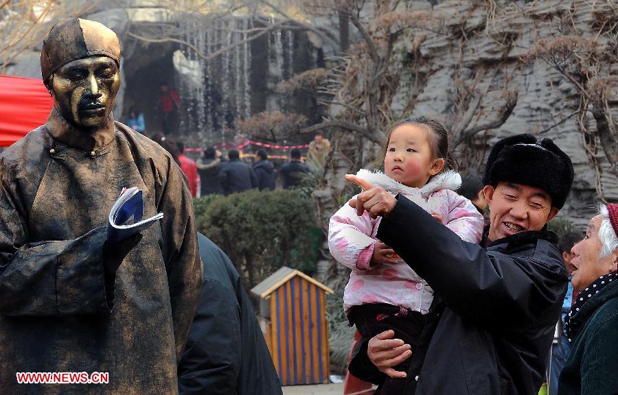 File photo taken on Feb. 8, 2011 shows visitors look at a cosplayer at a temple fair in Kaifeng, central China's Henan Province. Temple fair in central China area is an important social activity for local people. The ancient temple fairs in central China were ceremonious sacrificial rituals. As time goes by, the focus of temple fair activities has shifted from "gods" to "people". The modern temple fair in central China is a platform of displaying folk culture as well as a channel for commodity circulation. According to statistics from the provincial cultural sector, there are about 35,000 temple fairs each year in Henan. (Xinhua/Wang Song)