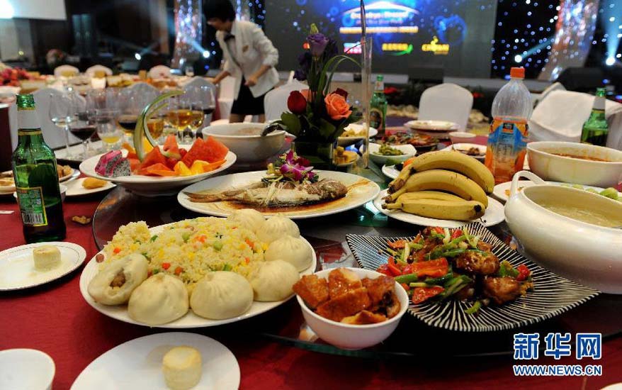 A waitress cleans up the dining table after a festival feast in a restaurant in Qingdao on Jan. 19, 2013. (Photo/Xinhua)