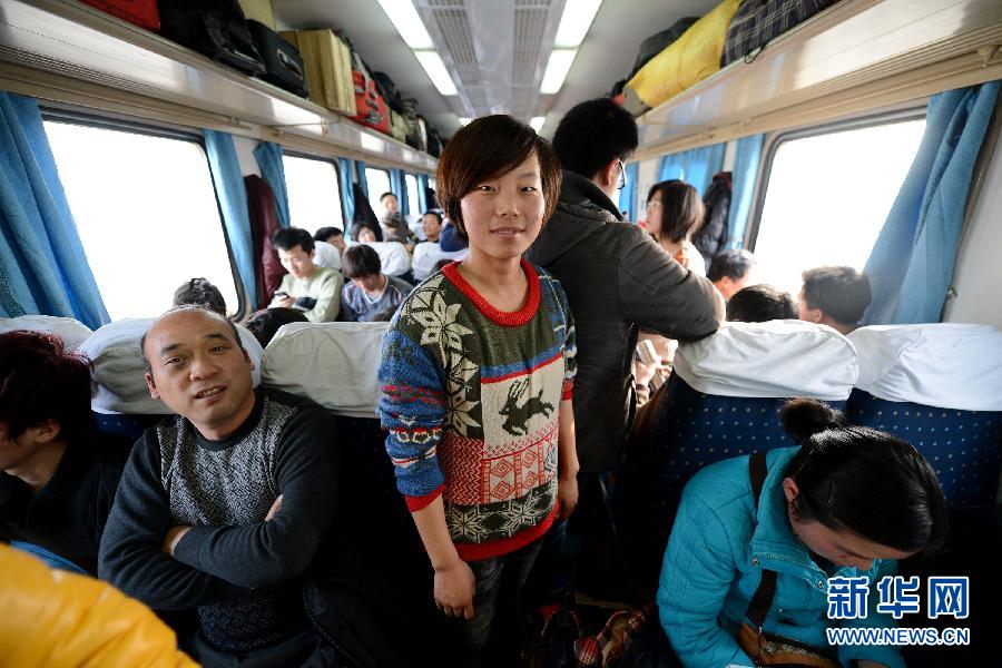 Huang Tingting (C) stands in the corridor of a train, Jan. 19, 2013.  “I only have to stand for one hour. I can stand it,” said Huang. (Photo/Xinhua)