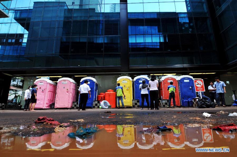 People queue in front of temporary toilets while the sanitation in the office building is failed by flood waters in Jakarta, Indoensia, Jan. 23, 2013. (Xinhua/Agung Kuncahya B.) 