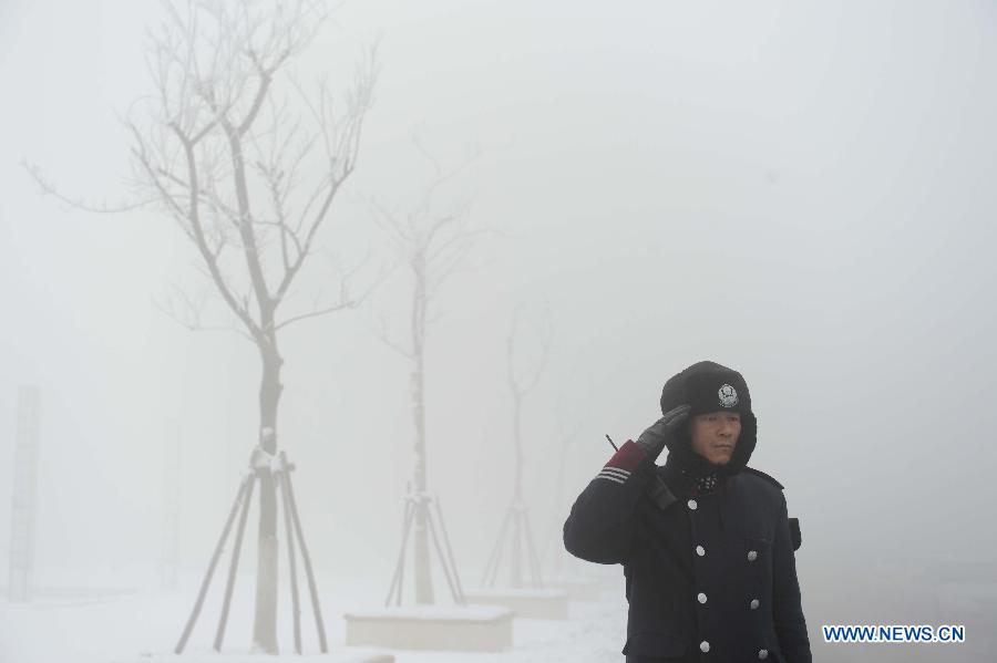 A security man is on guard in heavy fog in Binzhou City, east China's Shandong Province, Jan. 23, 2013. (Xinhua/Guo Xulei)