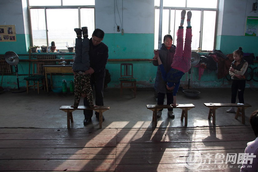 A couple of principals teach acrobatic skill to students. (Photo/ Yx.iqilu.com)