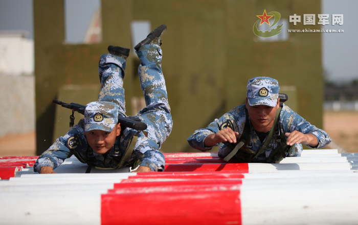 Special forces soldiers scramble on rolling logs. (Photo/ Chinamil.com.cn)