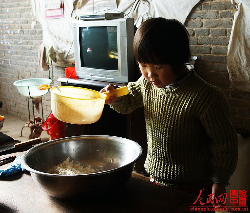 Liqing makes noodles for her mother.(Photo/People's Daily Online)