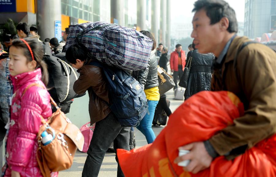 Passengers carry their luggage on the square of the train station in Chengdu, capital of southwest China's Sichuan Province, Jan. 24, 2013. As the spring festival approaches, more than more people started their journey home. (Xinhua/Xue Yubin)