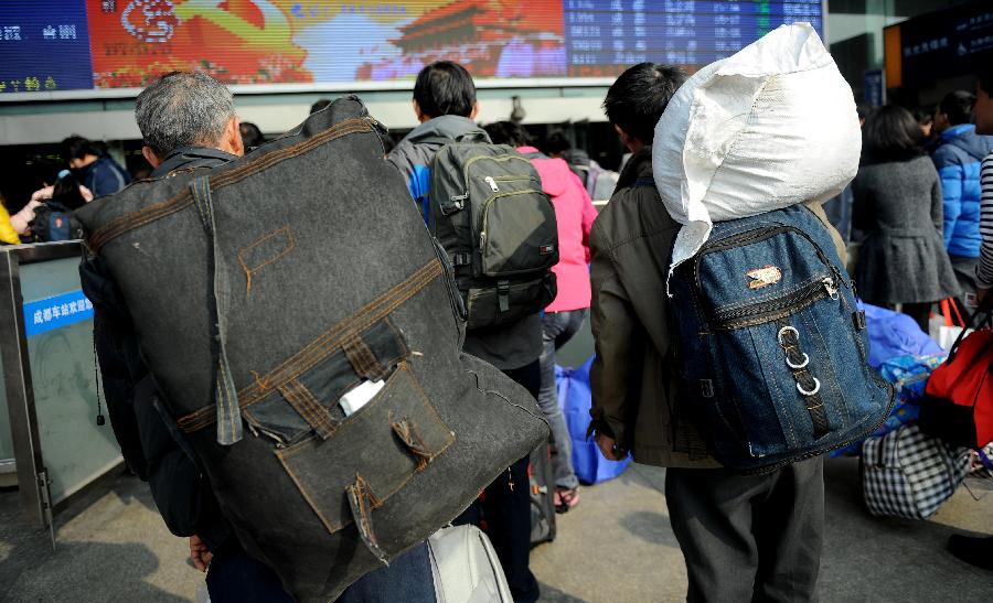 Passengers carry their luggage on the square of the train station in Chengdu, capital of southwest China's Sichuan Province, Jan. 24, 2013. As the spring festival approaches, more than more people started their journey home. (Xinhua/Xue Yubin) 