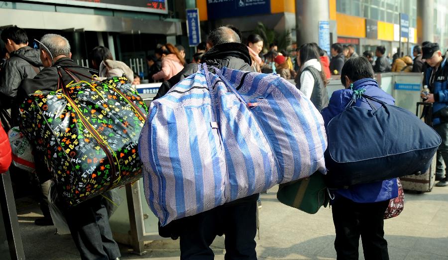 Passengers carry their luggage on the square of the train station in Chengdu, capital of southwest China's Sichuan Province, Jan. 24, 2013. As the spring festival approaches, more than more people started their journey home. (Xinhua/Xue Yubin) 