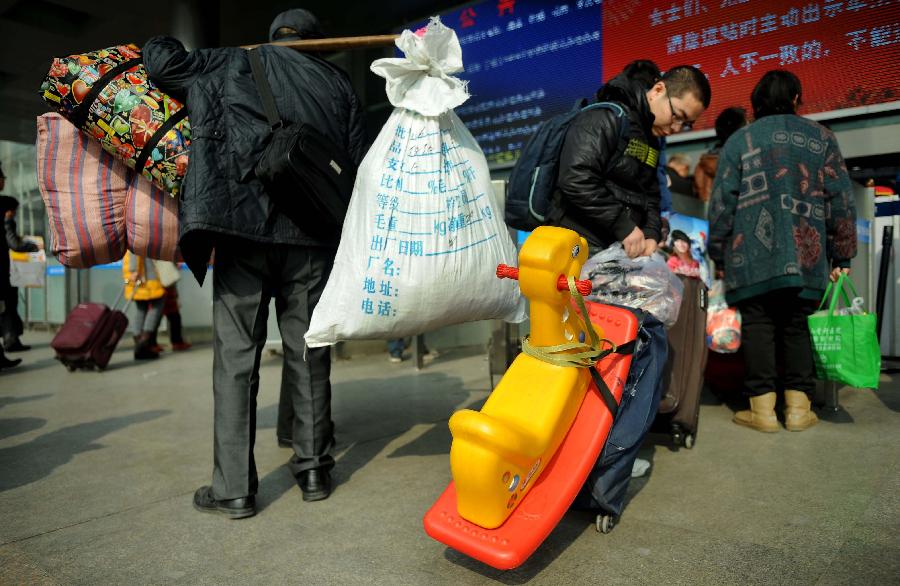 Passengers carry their luggage on the square of the train station in Chengdu, capital of southwest China's Sichuan Province, Jan. 24, 2013. As the spring festival approaches, more than more people started their journey home. (Xinhua/Xue Yubin) 