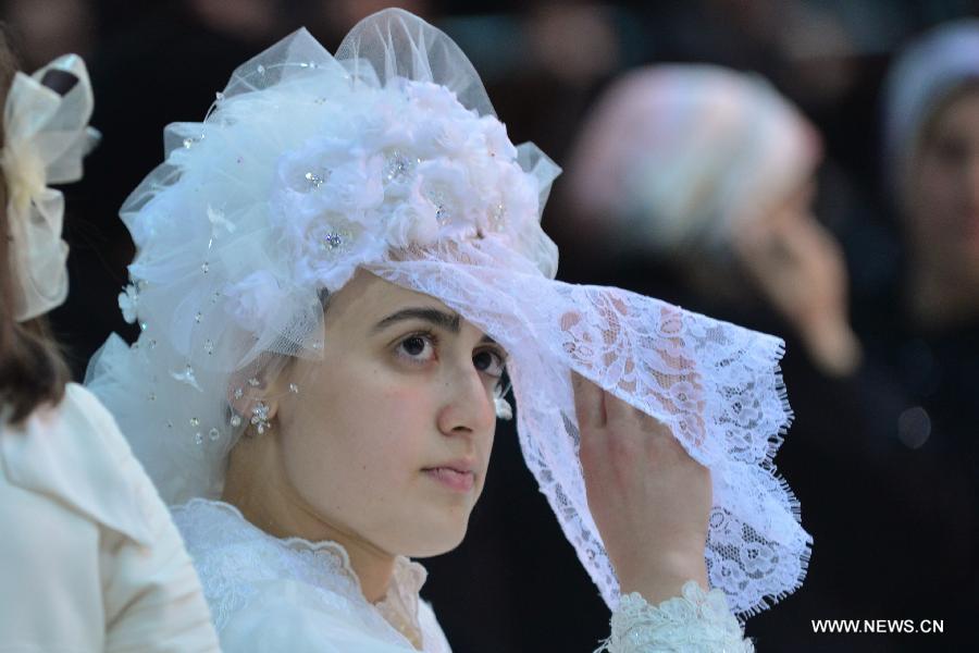 The bride, the first granddaughter of Grand Rabbi of the Satmar hassidic dynasty Rabbi Zalman Leib Teitelbaum, waits for dancing during her wedding in Israeli town of Beit Shemesh, on Jan. 24, 2013. The wedding was held here from the evening of Jan. 23 to the morning of Jan. 24. Some 5,000 guests attended the traditional Jewish wedding. (Xinhua/Yin Dongxun)