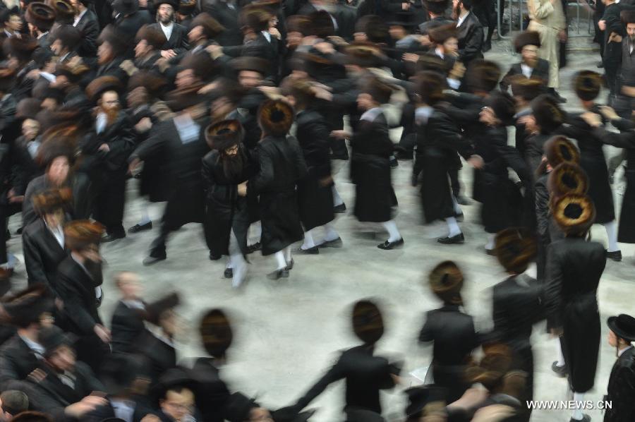 Ultra-Orthodox Jews dance during the wedding of the first granddaughter of Grand Rabbi of the Satmar hassidic dynasty Rabbi Zalman Leib Teitelbaum, in Israeli town of Beit Shemesh, on Jan. 23, 2013. The wedding was held here from the evening of Jan. 23 to the morning of Jan. 24. Some 5,000 guests attended the traditional Jewish wedding. (Xinhua/Yin Dongxun)