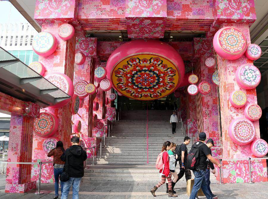 Tourists walk past the door of the Harbour City in Tsim Sha Tsui, south China's Hong Kong, Jan. 24, 2013. As the Spring Festival is approaching, various decorations appeared in shopping malls in celebration of the Chinese Lunar New Year. (Xinhua/Li Peng) 