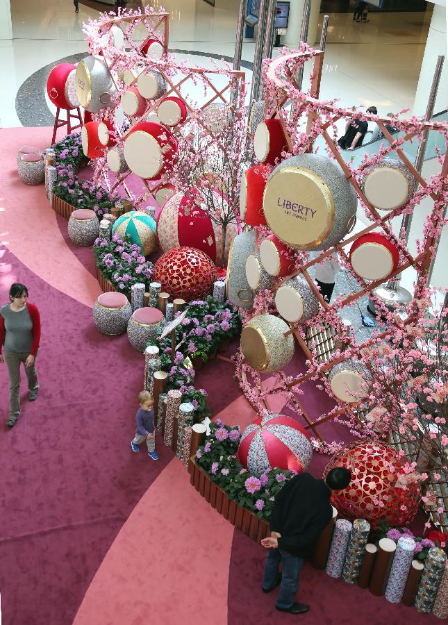 A couple taking their child look at decorations at a shopping mall in Kowloon, south China's Hong Kong, Jan. 24, 2013. As the Spring Festival is approaching, various decorations appeared in shopping malls in celebration of the Chinese Lunar New Year. (Xinhua/Li Peng) 