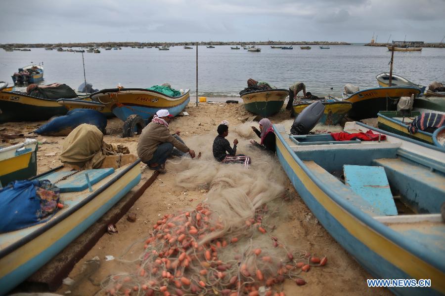 Palestinian fisherwoman Madeline Kolab repairs her fishing net on the sea beach in Gaza City, on Jan. 23, 2013. Sixteen-year-old Madeline Kolab is a fisherwoman. Her father, a veteran fisherman, became disabled, and therefore, she quit school after the ninth grade to take the job. "I don't care about what people say. I only care about feeding my family although fishing in Gaza is risky. The Israeli navy allows boats only a few miles offshore." Kolab said. (Xinhua/Wissam Nassar)