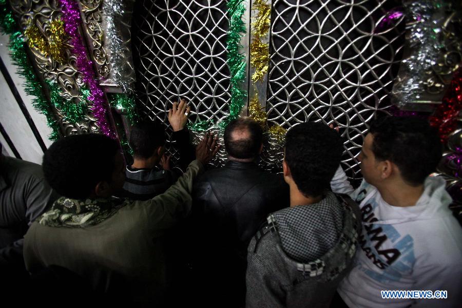 Sufi Muslims touch the wall of Al-Hussein mosque in sufi celebration rituals to celebrate the birth of Prophet Mohammed in Cairo, Egypt, Jan. 24, 2013. Hundreds of millions of Muslims celebrated the anniversary of Prophet Muhammad's birth all over the world. (Xinhua/Amru Salahuddien)
