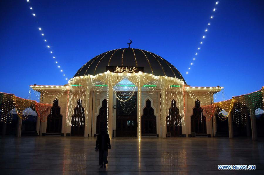 A Muslim woman walks in the illuminated mosque during celebrations ahead of Eid-e-Milad-un-Nabi, marking the birth anniversary of the Islam's Prophet Mohammed, in northwest Pakistan's Peshawar on Jan. 24, 2013. (Xinhua Photo/Umar Qayyum)