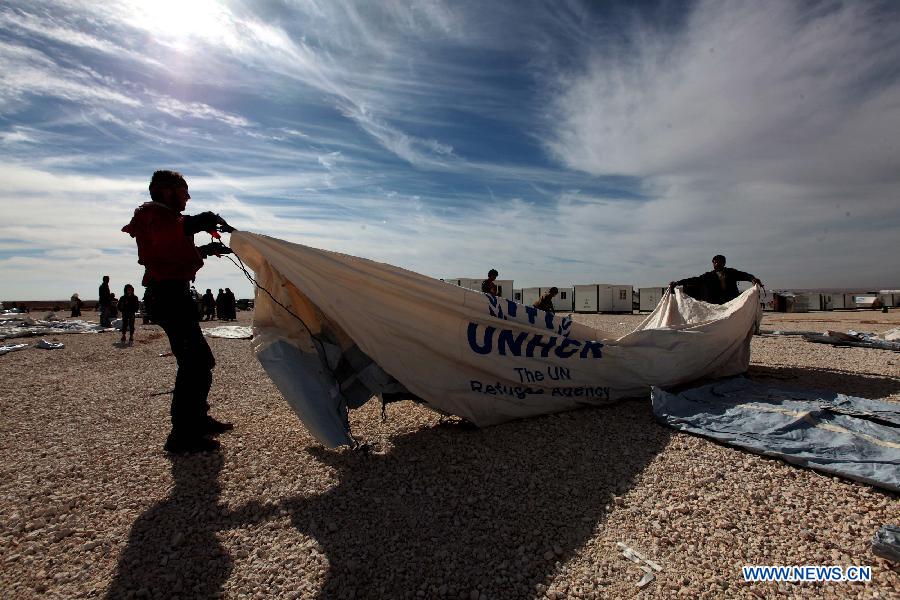 Relief workers erect a tent in Zaatari refugee camp, near the desert town of Mafraq, northeast of Amman, Jan. 24, 2013. The past six days witnessed a record surge in the number of Syrian refugees seeking safety in Jordan. The number of refugees has pushed up the Syrian population in Jordan to around 300,000. (Xinhua/Mohammad Abu Ghosh) 