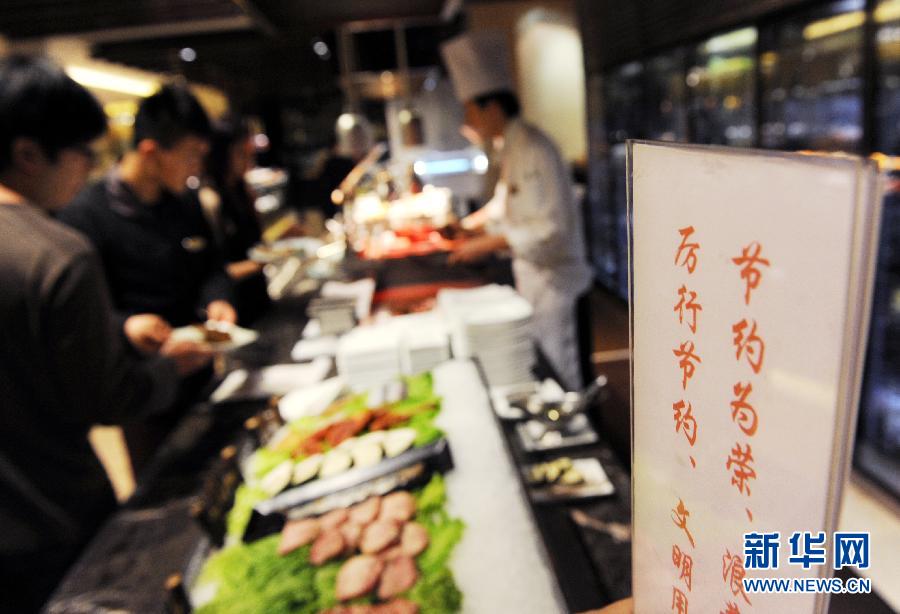 A sign with food-saving slogan is erected in a cafeteria in Qingdao, Shandong province, Jan. 24.  Stirred by an exposure on astonishing food waste on Chinese tables, “Did you empty the dishes today?” has become the most popular question in China. As response, restaurants and government departments take actions to eliminate food waste. Showing an empty dish also turns a new fashion among Chinese netizens.  (Xinhua/Li Ziheng)