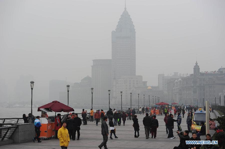 Tourists visit the Bund in the fog in east China's Shanghai Municipality, Jan. 24, 2013. Fog hit Shanghai Thursday. (Xinhua/Lai Xinlin) 