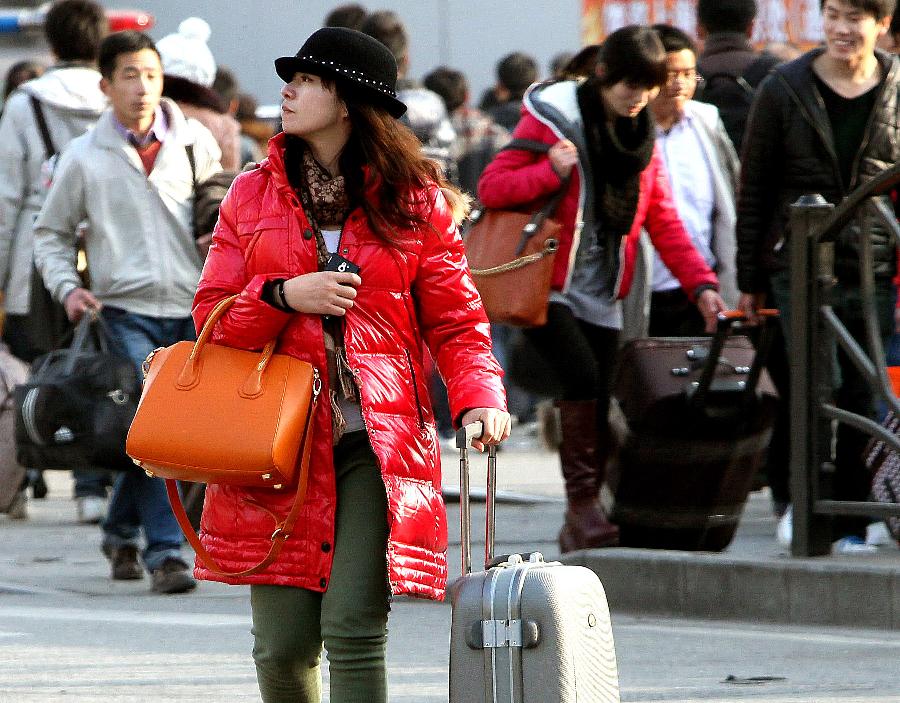 Passengers carrying packages go to the Shanghai Railway Station in east China's Shanghai, Jan. 25, 2013. The 40-day Spring Festival travel rush will begin on Jan. 26. The Spring Festival, the most important occasion for a family reunion for the Chinese people, falls on the first day of the first month of the traditional Chinese lunar calendar, or Feb. 10 this year. The number of passengers would reach 3.407 billion person-time during the 2013 Spring Festival travel, an 8.6 percent increase year on year. (Xinhua/Chen Fei) 