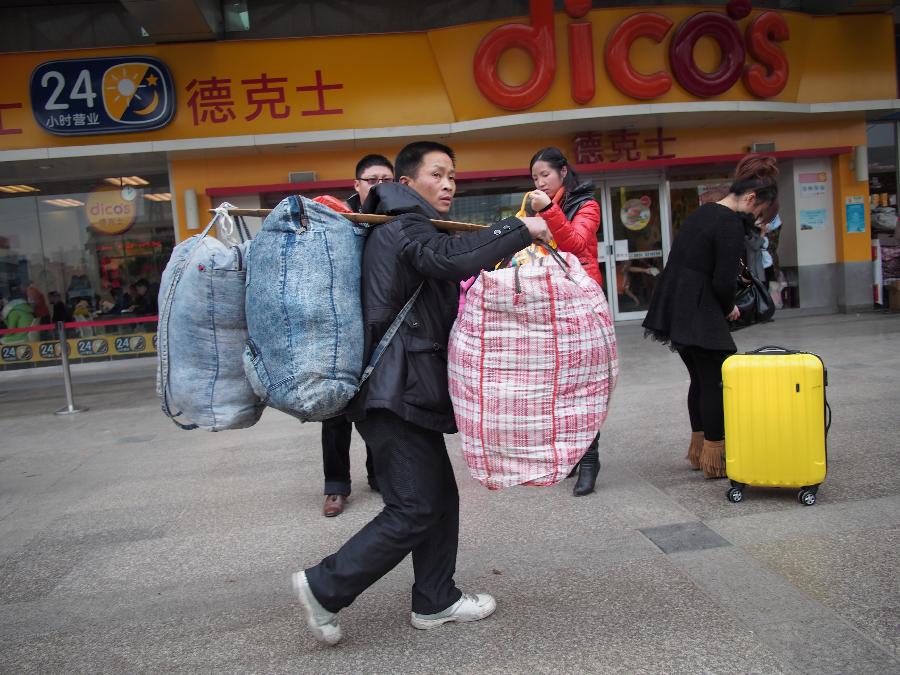 A passenger carries his luggage to enter the Guiyang Railway Station in Guiyang, capital of southwest China's Guizhou Province, Jan. 25, 2013. The most important Chinese holiday, the Spring Festival, falls on Feb. 10 and migrants want to get home to see their families. The Ministry of Railways forecast the holiday travel rush, which starts on Jan. 26, will last until March 6. (Xinhua/Liu Xu) 