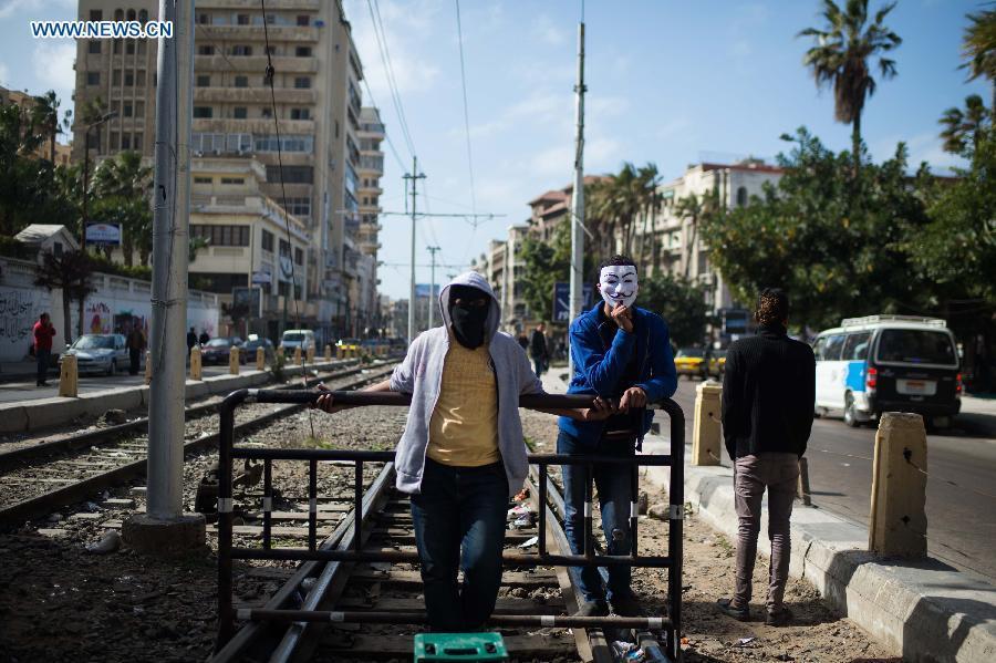 Egyptian protestors block the tram track near Al Qaed Ibrahim Mosque in Alexandria, the second biggest city of Egypt, on Jan. 25, 2013, marking the second anniversary of the 2011 unrest that toppled former leader Hosni Mubarak. (Xinhua/Qin Haishi)